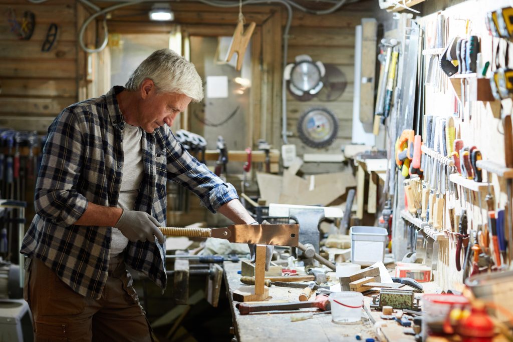 Woodworker operating table saw with blade guard in a well-lit, clutter-free shop